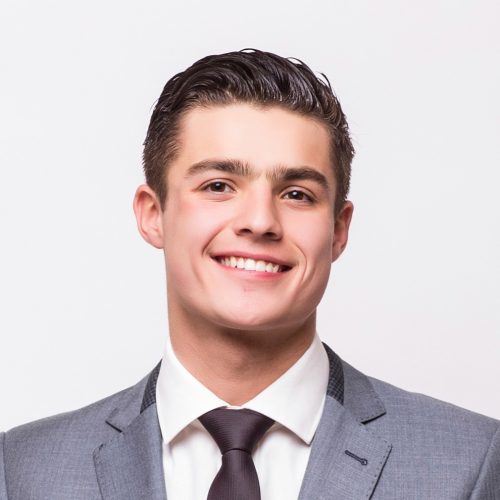 Happy business man wearing grey suit standing and folding arms